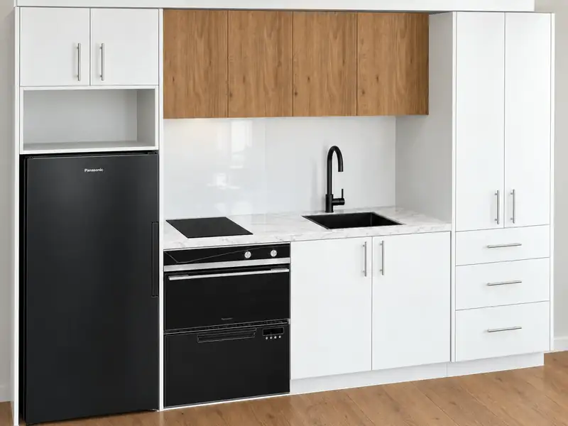 The 67 Dual Key kitchen render showing compact kitchen with ceramic cooktop, glass splashback and laminate benchtop